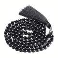 Long agate tassel necklace with geometric beads in multiple natural stone colours on a white background.