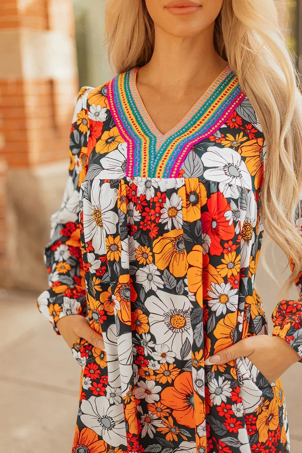 Orange floral print V-neck mini dress with long lace sleeves on a mannequin.