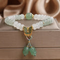 Green crystal abacus bead bracelet with butterfly charm and tassel detail, 17 cm length