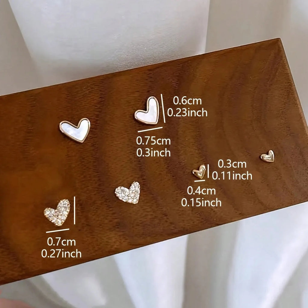 Three pairs of heart-shaped alloy earrings with electroplated finishes in gold, black, black-white, and pink colours