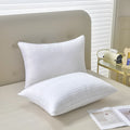 White cotton satin stripe feather pillow showing simple design on a bed.