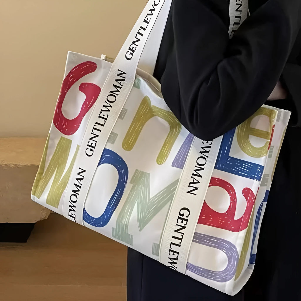 Large canvas tote bag with printed design options including letters and patterns.