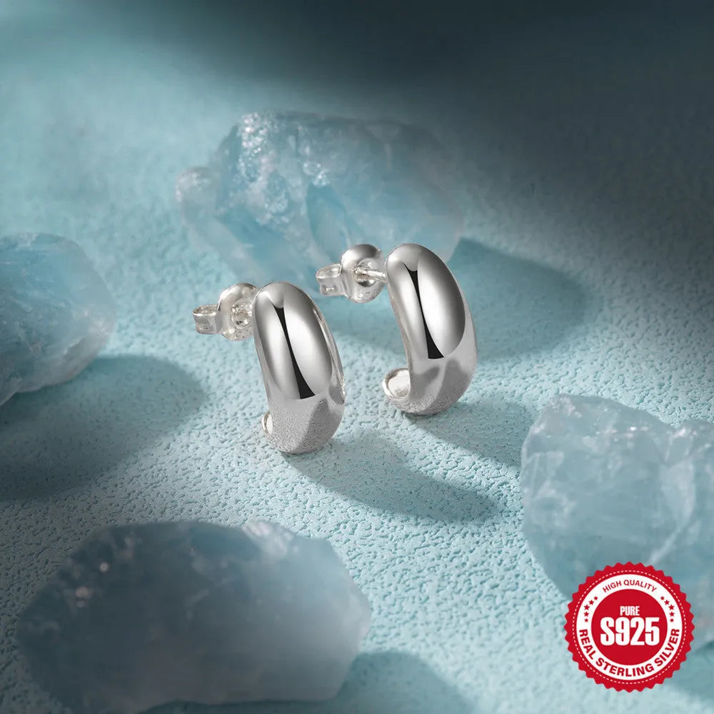 A pair of simple C-shaped ring stud earrings in 925 sterling silver, shown in both gold and silver colour options.