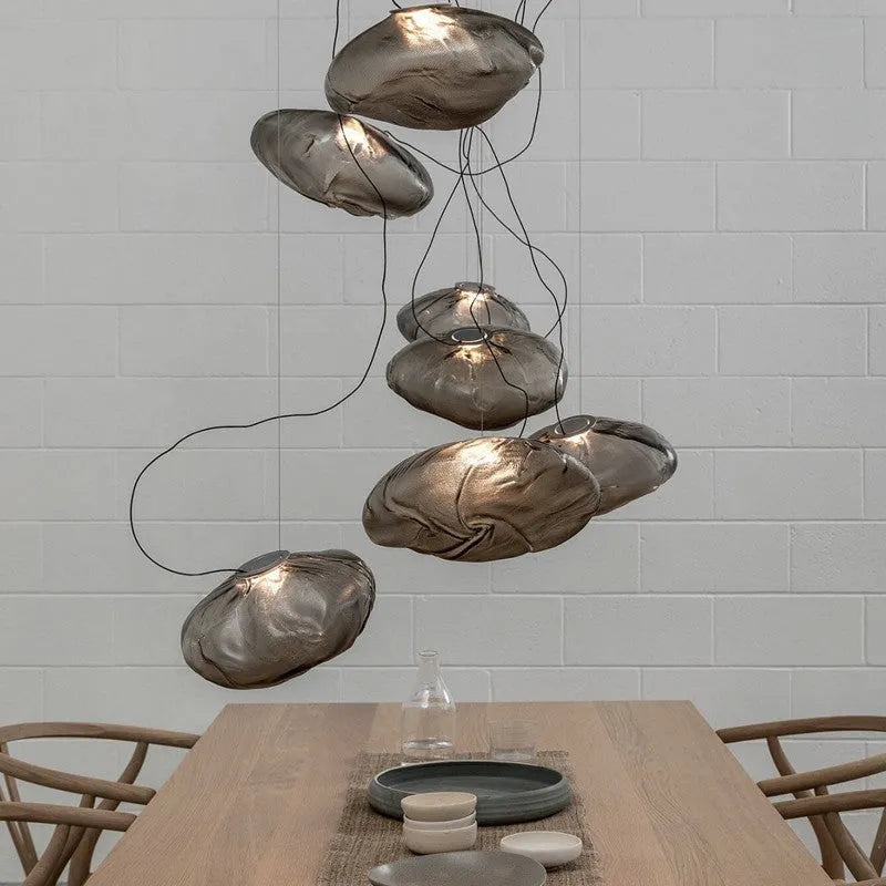 Modern fabric chandelier light with glass shade in amber, clear, or smoke grey, shown in small and large sizes.