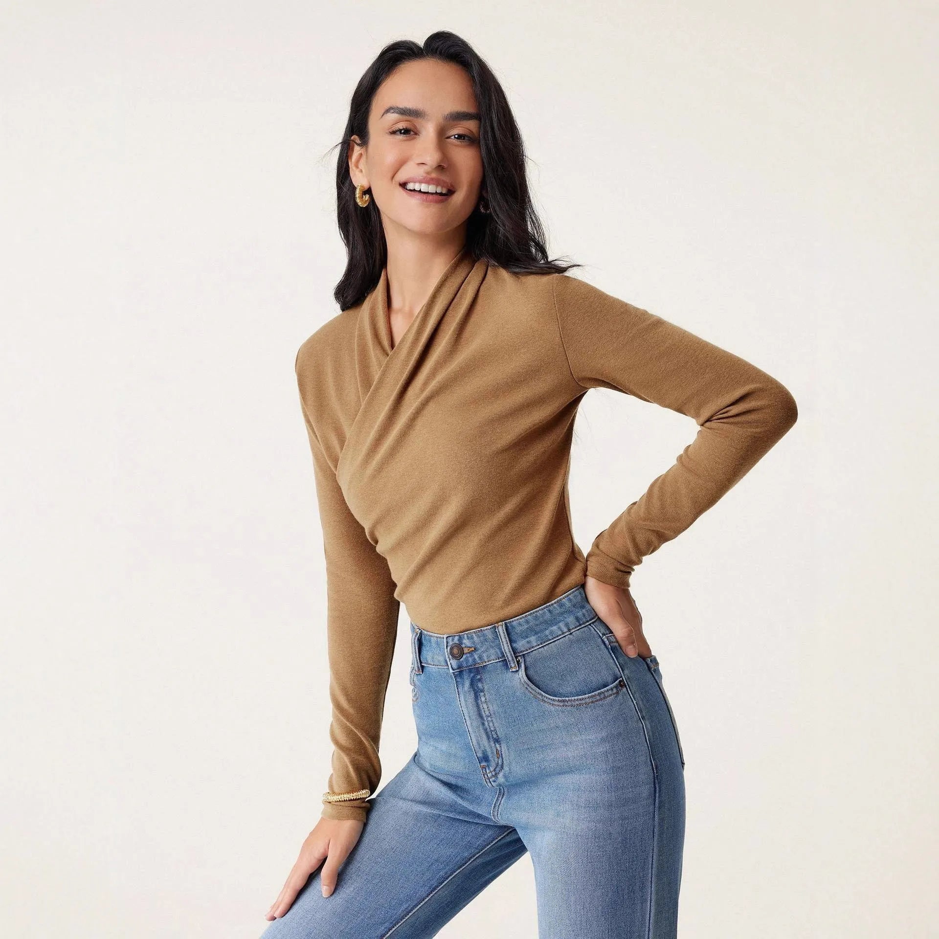 Camel-coloured slim fit women's long sleeve pullover sweater on a hanger.