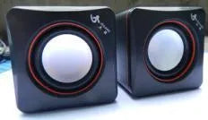 Small square black USB speaker for Model 700B computer on a desktop
