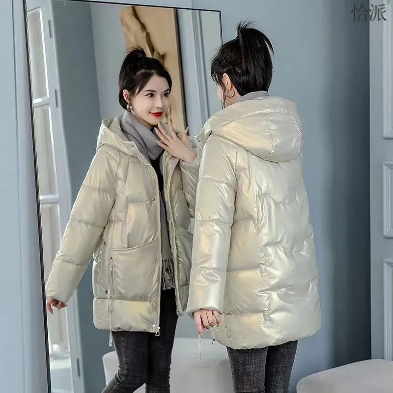 Green loose thick women's winter hooded jacket with long sleeves on a hanger.