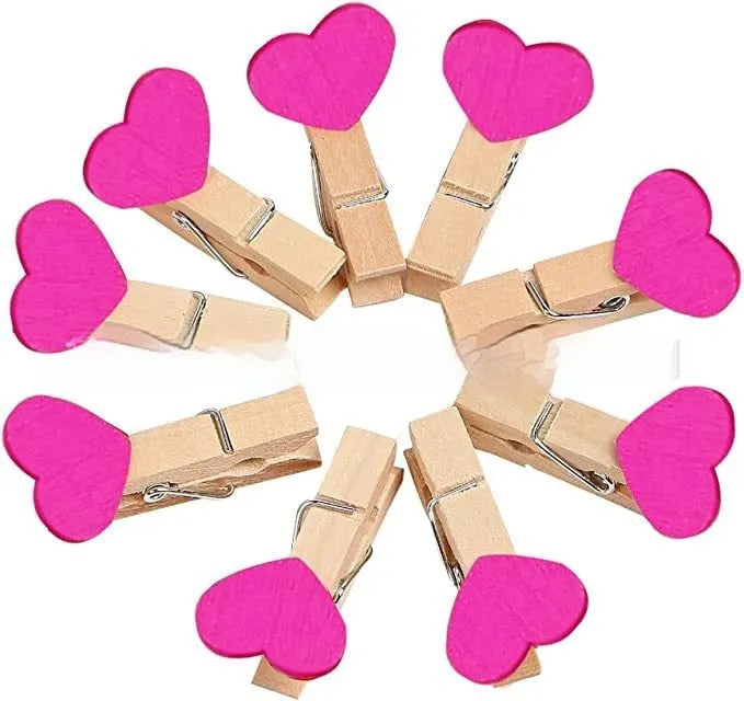 Set of five handmade solid wood heart-shaped clips in red, white, and rose red on a plain surface.