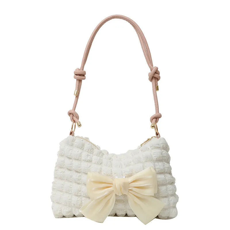 A horizontal square canvas women's handbag with a single shoulder strap, shown in pink with visible sewing thread details.
