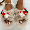 Women's black Christmas slippers with a large hairy decoration on the front, showing faux plush upper.
