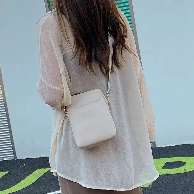 Women's solid colour PU crossbody shoulder bag showing compact dimensions and adjustable strap