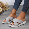 Women's black wedge peep-toe slippers with a cross-strap design and thick rubber sole.
