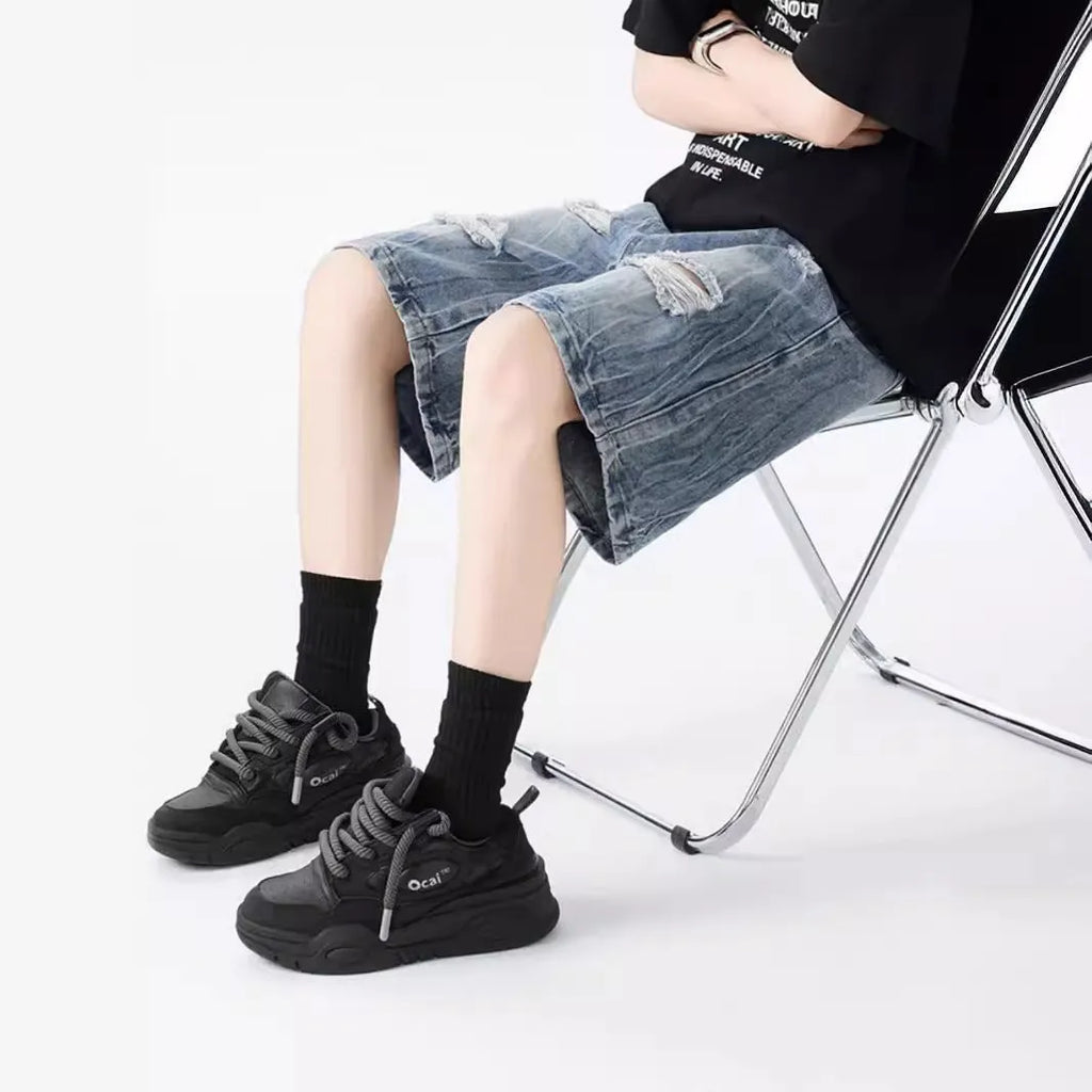 Men's loose fit distressed denim shorts with ripped knee detailing in retro style