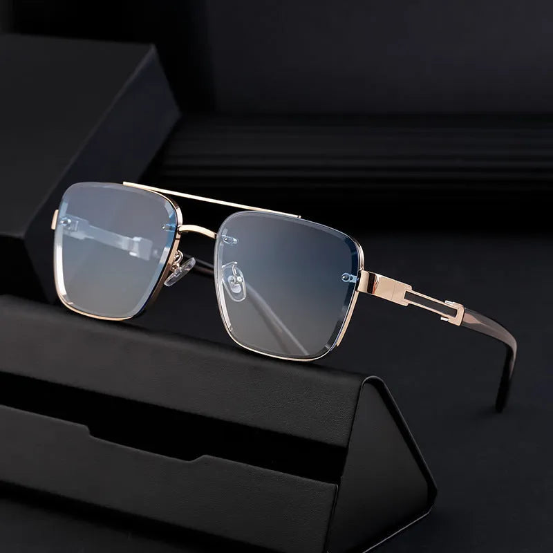 Men's vintage sunglasses with gold frame and grey lenses on a plain background.