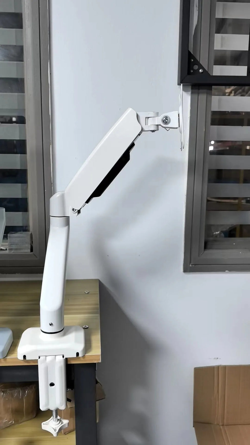 Black LCD screen rotating telescopic bracket elevated on a desk next to a monitor