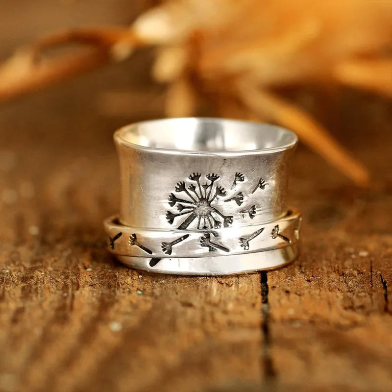 Silver rotatable flower ring on hand showing spinning floral design