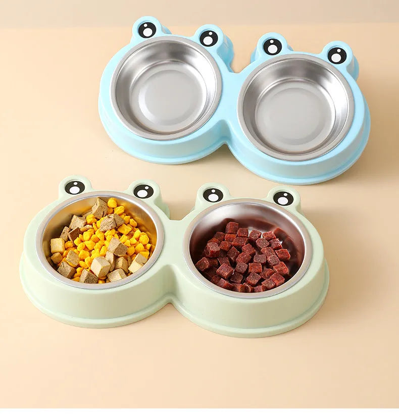 Blue stainless steel double pet bowl with frog design, showing separate food and water compartments on a non-slip base.