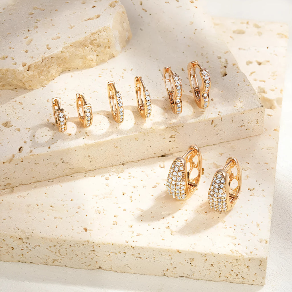 Gold plated heart shape ear clip earrings with crystal accents on white background