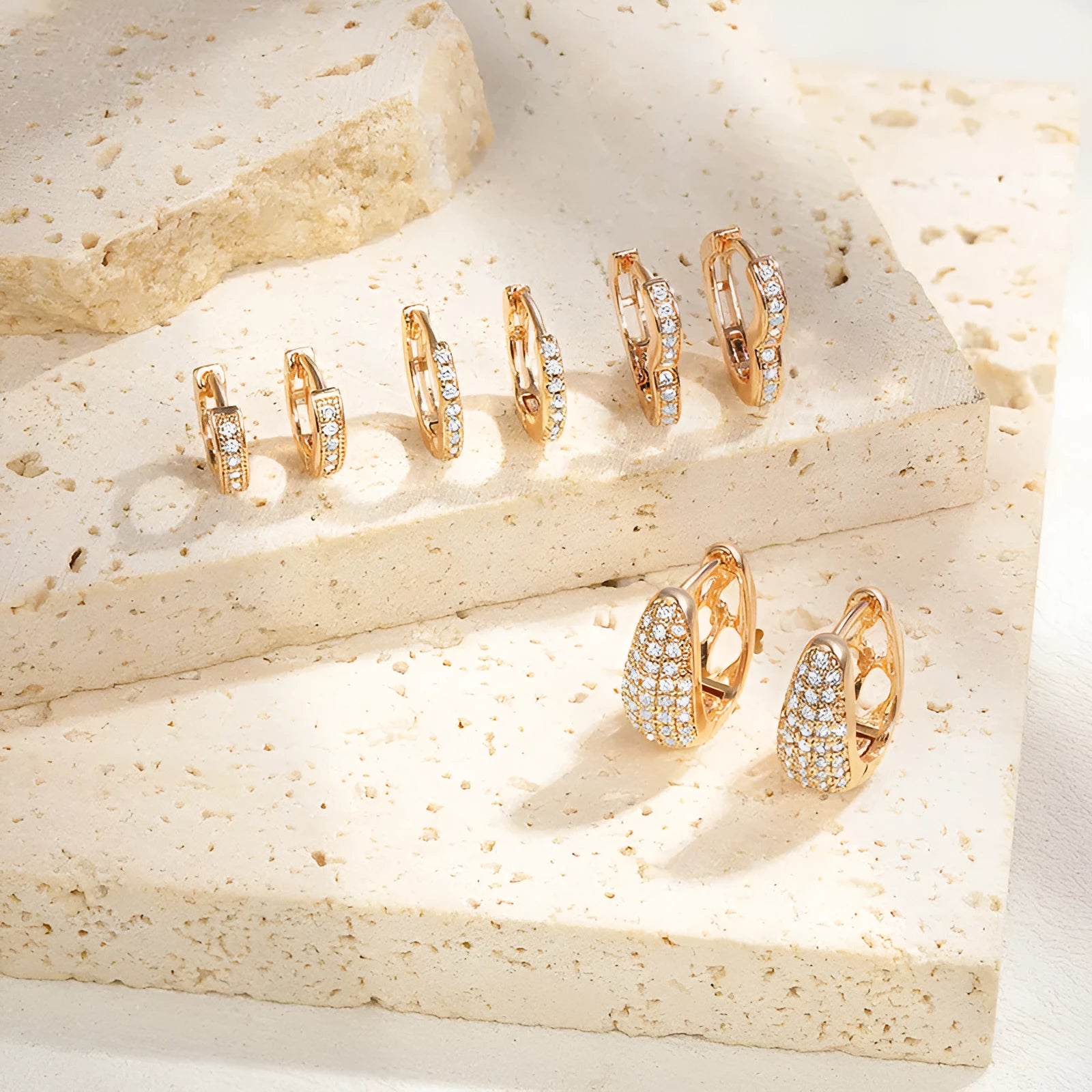 Gold plated heart shape ear clip earrings with crystal accents on white background