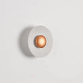 Round white and gold aluminium wall lamp mounted on a wall, LED light source visible.