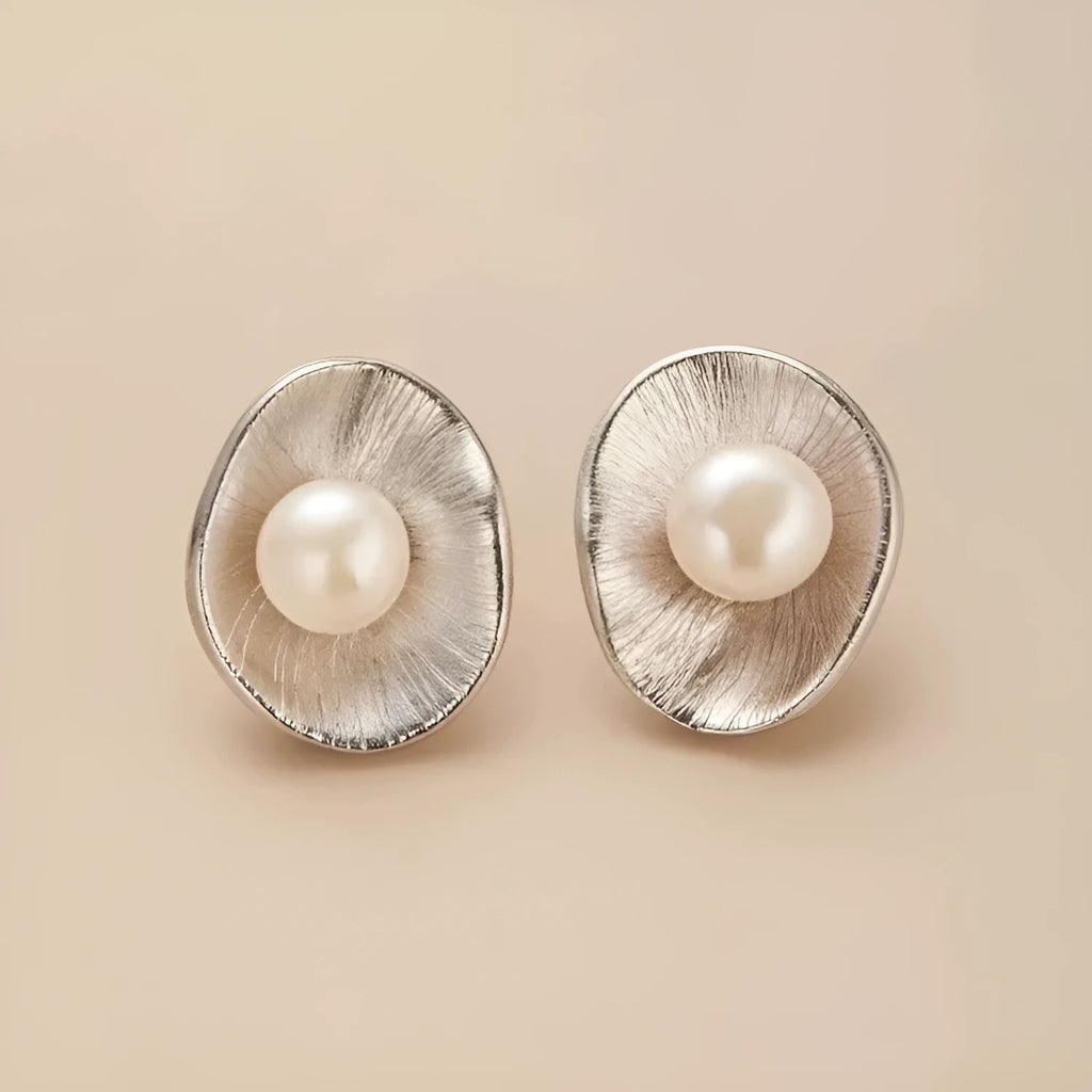 A pair of gold-coloured geometric sterling silver ear studs featuring a central pearl.