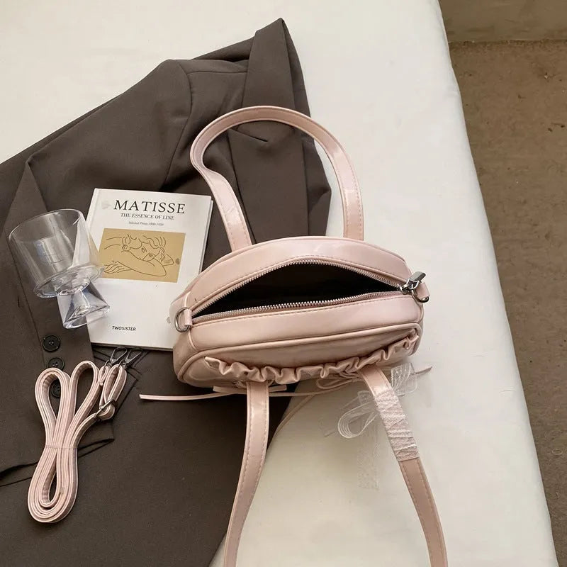 Women's casual shoulder handbag with bandage bow detail in PU material showing internal phone compartment