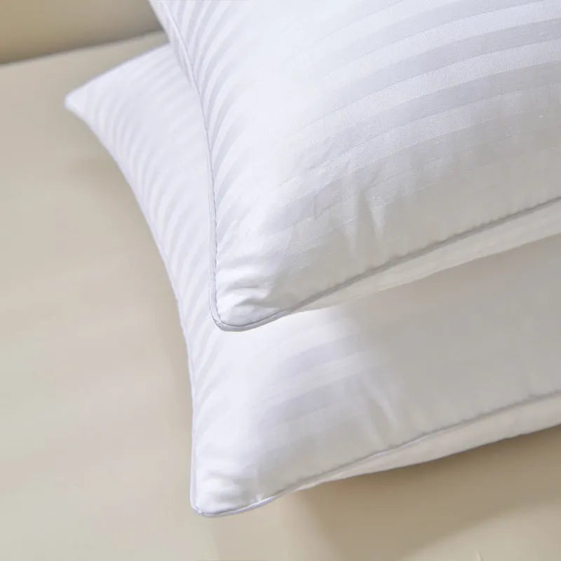 White cotton satin stripe feather pillow showing simple design on a bed.