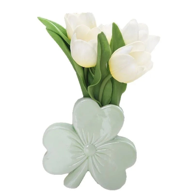 European style white porcelain ceramic vase in four colour options on a desktop.