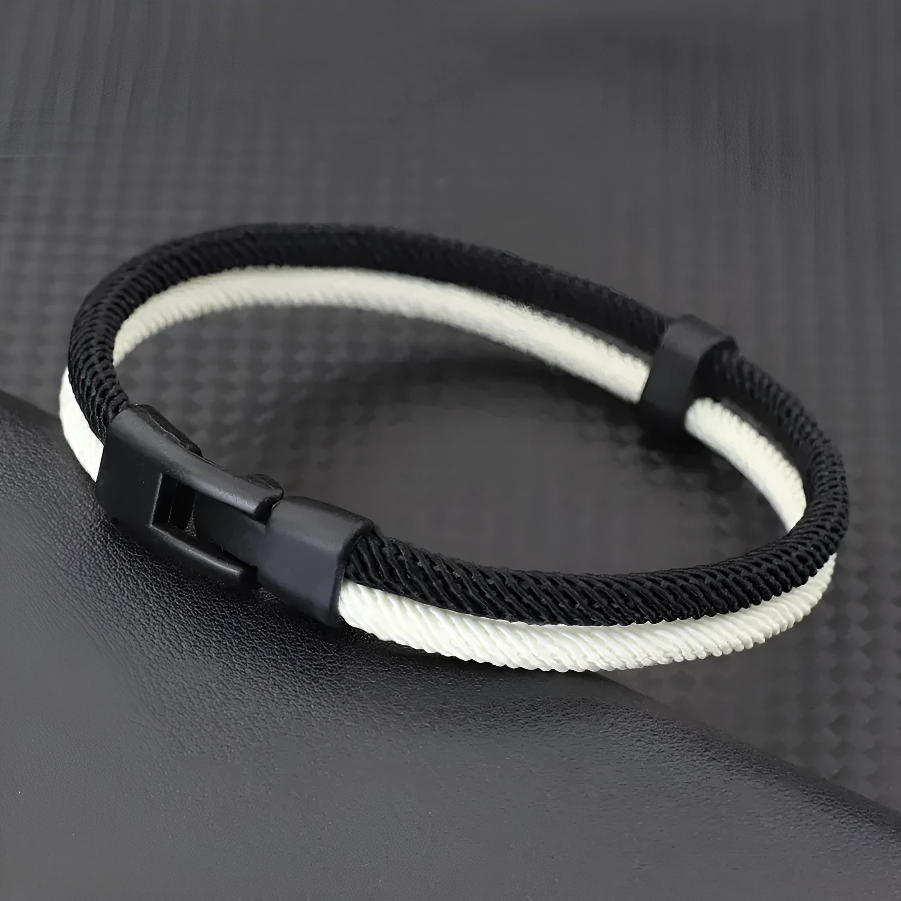 Black and white handmade woven hand strap made from Milan rope alloy showing woven texture