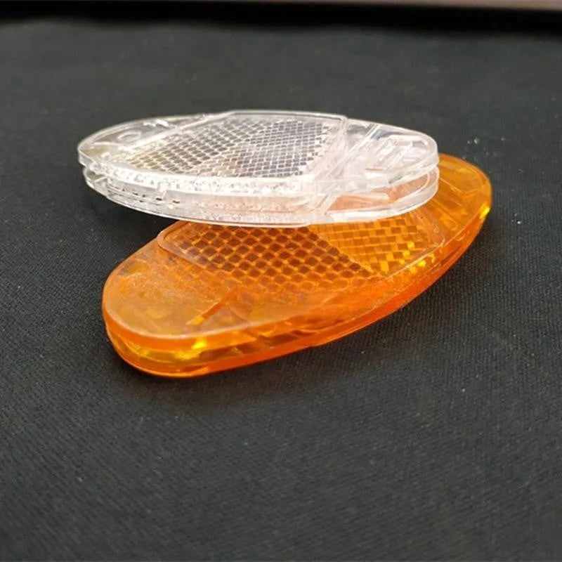 Yellow and white plastic bicycle spoke reflectors showing size of 7.2cm by 3.5cm.