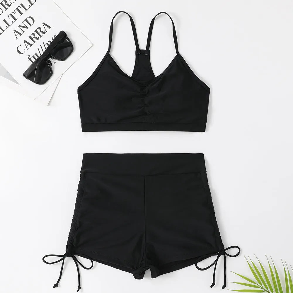 Women's black high-waist bikini swimsuit with split-side shorts and brief top.